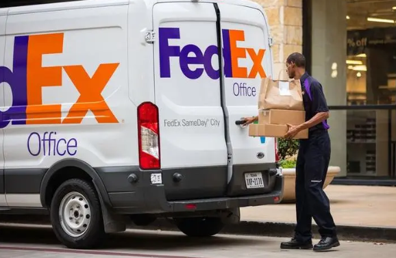 FedEx courier unloading parcels for door-to-door delivery